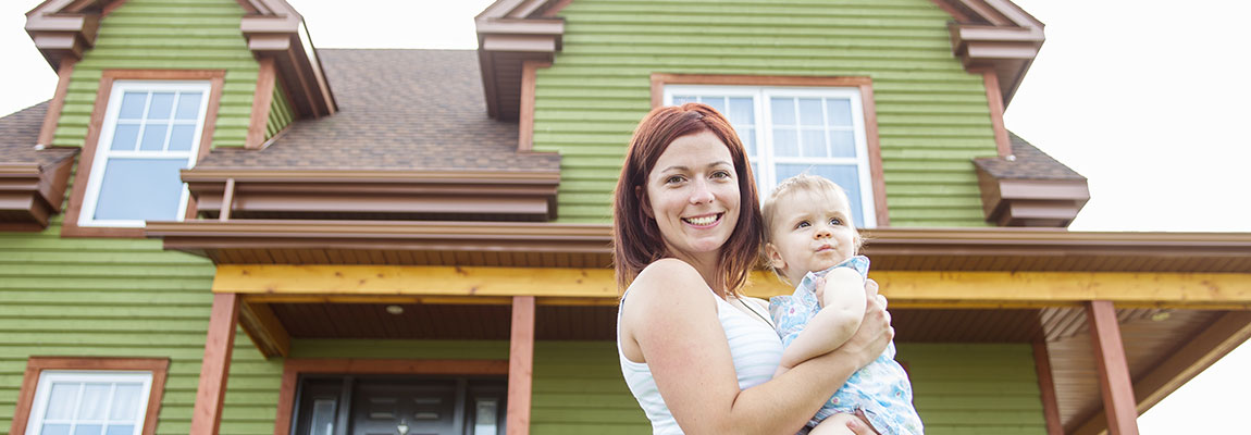 Happy mother and daughter outside of their new home